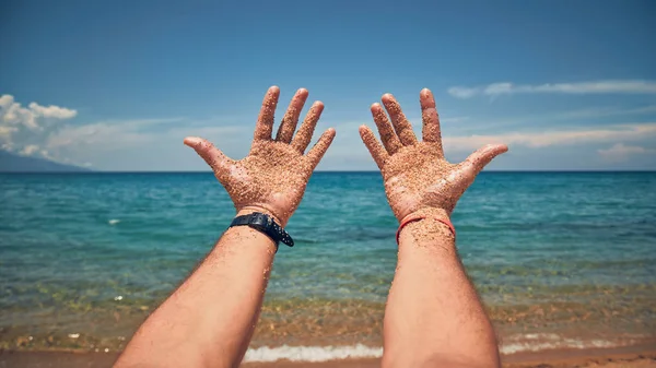 Kumlu bir tropik plajda elleri ile oynayan bir adam.. — Stok fotoğraf