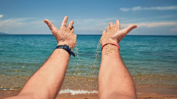 Kumlu bir tropik plajda elleri ile oynayan bir adam.. — Stok fotoğraf
