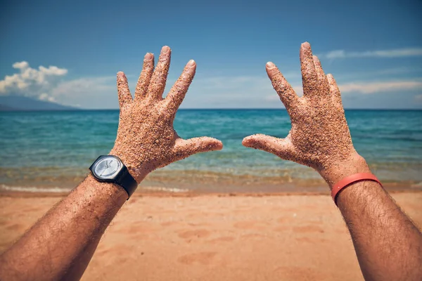 在热带沙滩上用手玩耍的人. — 图库照片