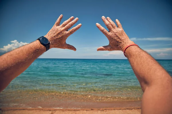 Kumlu bir tropik plajda elleri ile oynayan bir adam.. — Stok fotoğraf