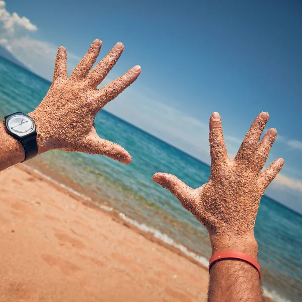在热带沙滩上用手玩耍的人. — 图库照片