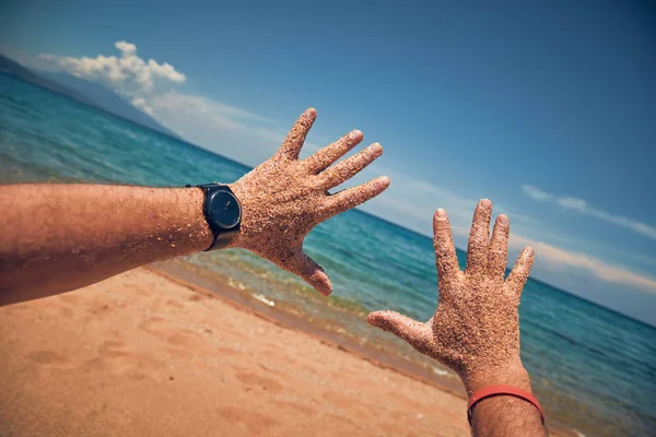 Hombre jugando con sus manos en una playa tropical de arena . — Foto de Stock