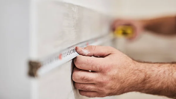 Worksman using tape measure for home renovation. Royalty Free Stock Images