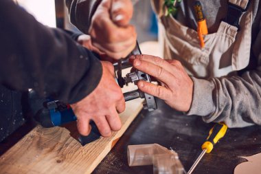 Erkek marangoz antika bir atölyede eski ahşap üzerinde çalışıyor..