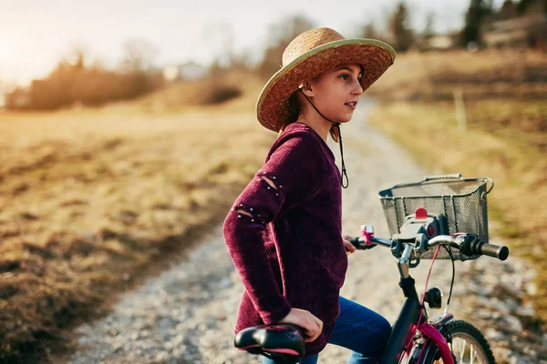 Nettes kleines zehnjähriges Mädchen fährt Fahrrad auf dem Land. — Stockfoto