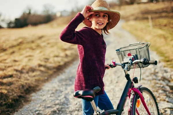 Nettes kleines zehnjähriges Mädchen fährt Fahrrad auf dem Land. — Stockfoto