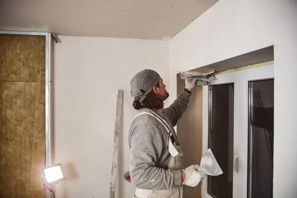 Trabajador enyesando paredes de yeso dentro de la casa . — Foto de Stock
