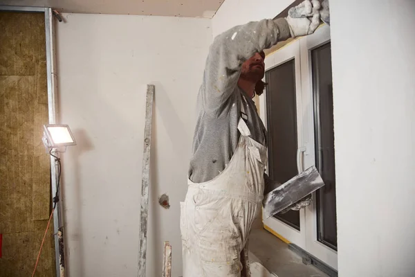 Dělník sádrovající stěny uvnitř domu. — Stock fotografie