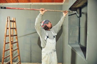 Kapalı bir uzatıcı silindir ile ressam boyama duvarları.