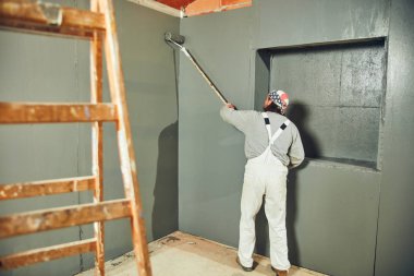 Kapalı bir uzatıcı silindir ile ressam boyama duvarları.