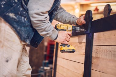 Erkek marangoz antika bir atölyede eski ahşap üzerinde çalışıyor..