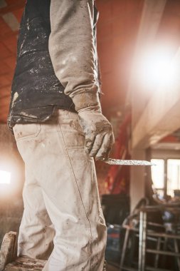 Gerçek inşaat işçisi yeni evin içinde bir duvar yapma.