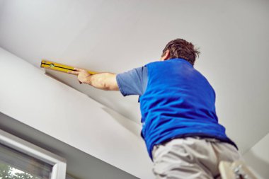 İşçi evin içindeki duvarlar için balon seviyesini kullanıyor - renovatio