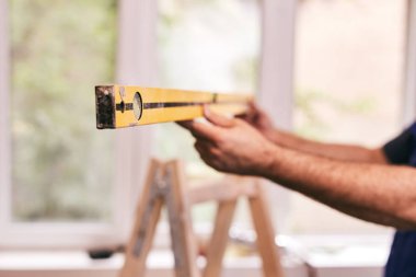 İşçi evin içindeki duvarlar için balon seviyesini kullanıyor - renovatio