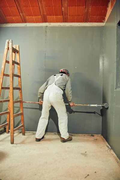 Festő festés falak egy Extender görgős beltéri. — Stock Fotó