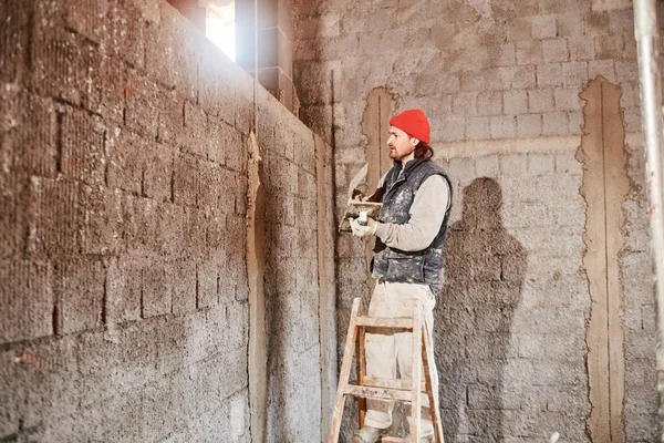 Real construction worker making a wall inside the new house. — Stock Photo, Image
