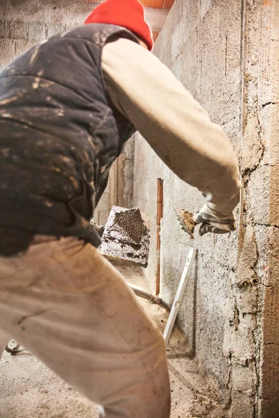 Pekerja konstruksi yang sebenarnya membuat dinding di dalam rumah baru . — Stok Foto