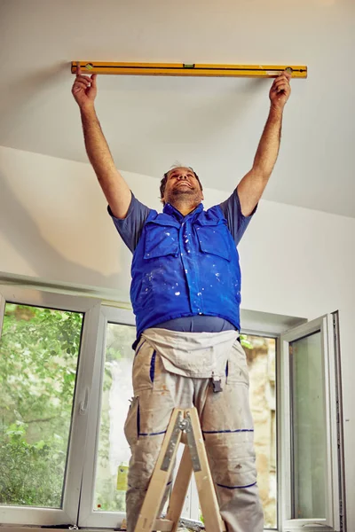Trabajador utilizando el nivel de burbuja para las paredes dentro de la casa - renovación — Foto de Stock