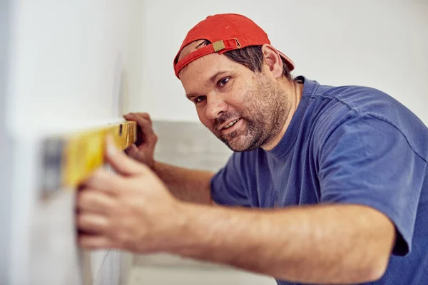 Trabajador utilizando el nivel de burbuja para las paredes y azulejos dentro de la casa  - — Foto de Stock