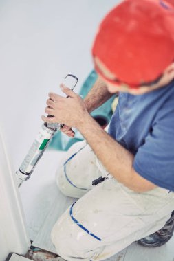 İşçi ev içinde duvarlar ve kapı çerçevesi için silikon kullanarak 