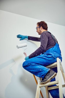 Ev içinde işçi boyama duvarları-yenileme düzeltmeleri.