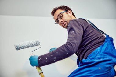 Ev içinde işçi boyama duvarları-yenileme düzeltmeleri.