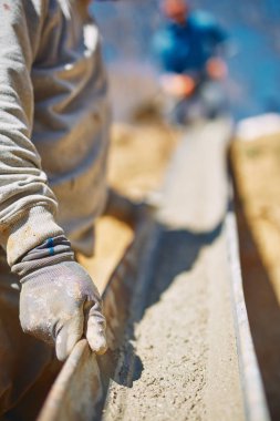 Ağır bir sitede inşaat işçisi sıkı çalışma yapıyor.