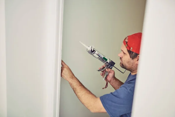 Работник, использующий силикон для стен и плитки внутри дома - рен — стоковое фото