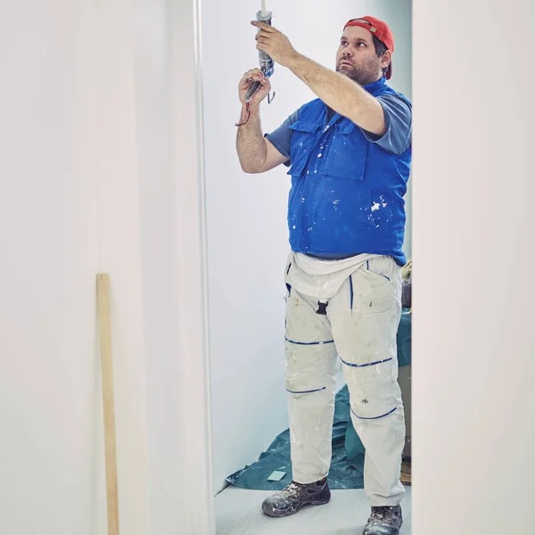 Worker using silicone for walls and door frame inside the house — Stock Photo, Image