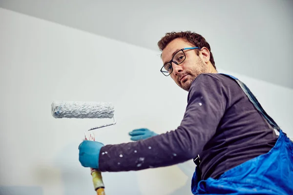 Arbeiter streicht Wände im Haus - Renovierung repariert. — Stockfoto