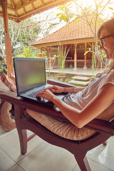 Fille en utilisant un ordinateur portable sur une véranda / terrasse à la maison . — Photo