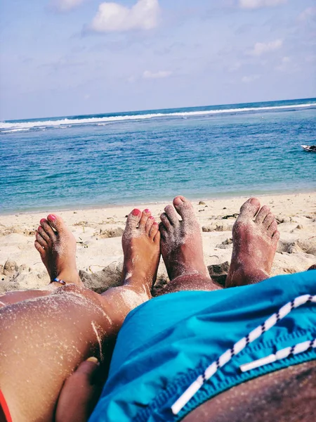 Pareja tumbada y disfrutando en una playa tropical de arena . — Foto de Stock