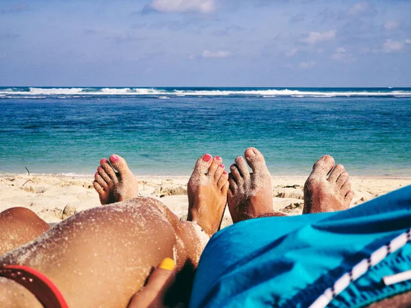 Pareja tumbada y disfrutando en una playa tropical de arena . — Foto de Stock