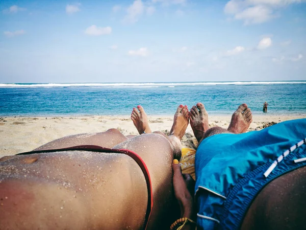 Pareja tumbada y disfrutando en una playa tropical de arena . — Foto de Stock