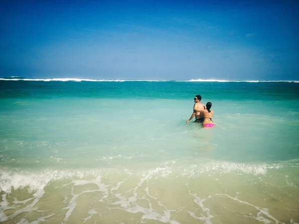 Pareja disfrutando en una playa tropical océano de arena . — Foto de Stock