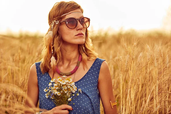Жінка з букетом квітів на пшеничному полі . — стокове фото