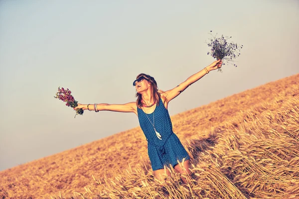 Дівчина тримає квіти і руки в повітрі . — стокове фото