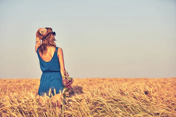 Donna con mazzo di fiori in un campo di grano . — Foto Stock