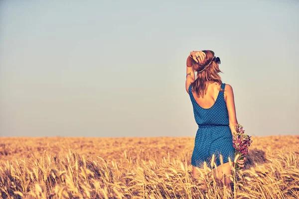 Donna con mazzo di fiori in un campo di grano . — Foto Stock