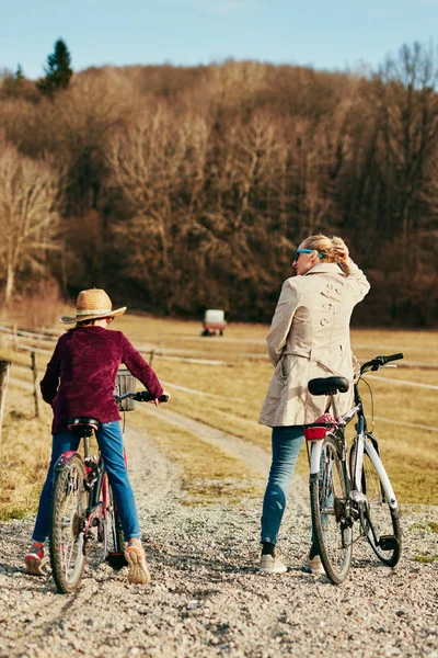 Anya és lánya kerékpáron, vidéken. — Stock Fotó