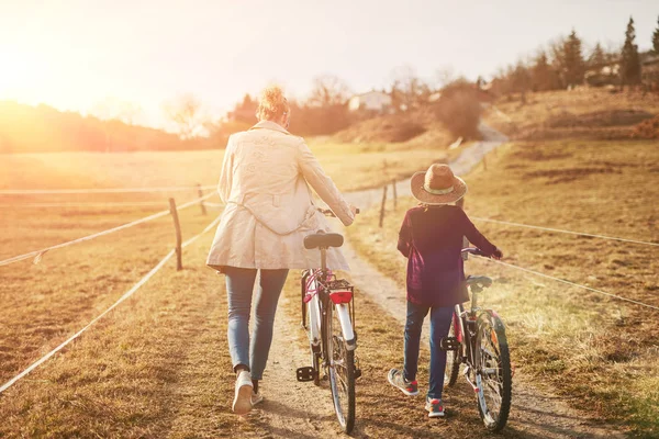 Мати і дочка з велосипедами на сільській місцевості . — стокове фото