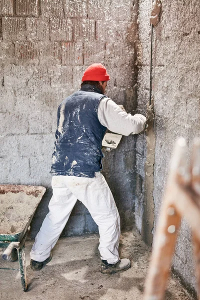 Vrai ouvrier de la construction faisant un mur à l'intérieur de la nouvelle maison . — Photo