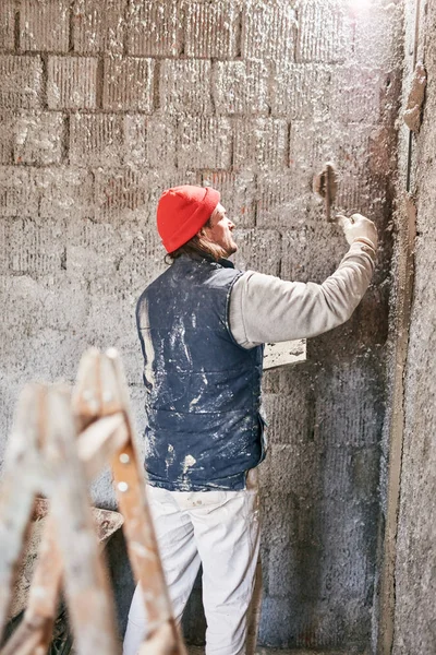 Vrai ouvrier de la construction faisant un mur à l'intérieur de la nouvelle maison . — Photo