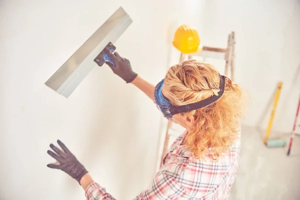 Werkende vrouw bepleistering/schilderen muren in het huis. — Stockfoto
