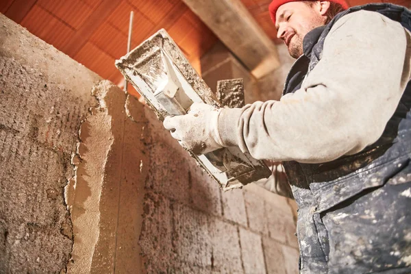 Vrai ouvrier de la construction faisant un mur à l'intérieur de la nouvelle maison . — Photo