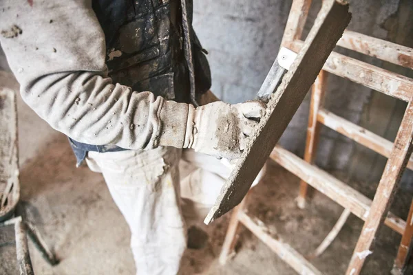 Pekerja konstruksi yang sebenarnya membuat dinding di dalam rumah baru . — Stok Foto
