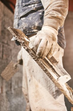 Gerçek inşaat işçisi yeni evin içinde bir duvar yapma.