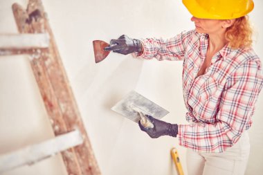 Çalışan kadın sıva / evin içinde duvarlar boyama.