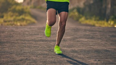 Banliyö dağ yolunda yokuş aşağı/yokuş yukarı adam jogging.