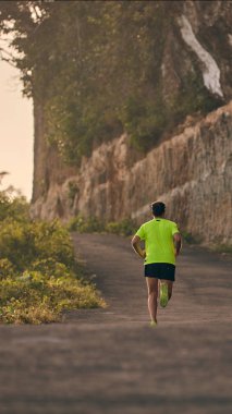 Banliyö dağ yolunda yokuş aşağı/yokuş yukarı adam jogging.